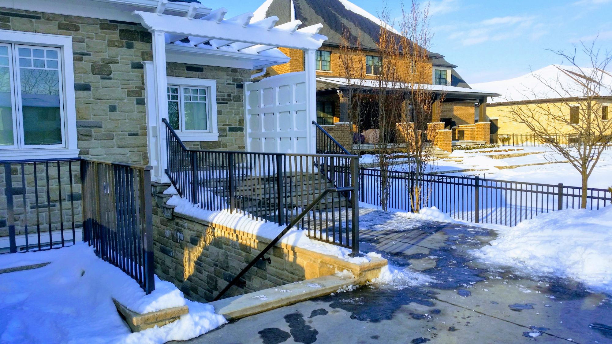 During cold winter days we installed this set of custom railings at a new build in Kingsville. Topping the angel stone, you should only install exterior railings with stainless steel anchors. To make the handrail work, we had to custom weld the grab rail to connect back into the top post. If you look int the background, admist all the snow - you can see the fence around the house