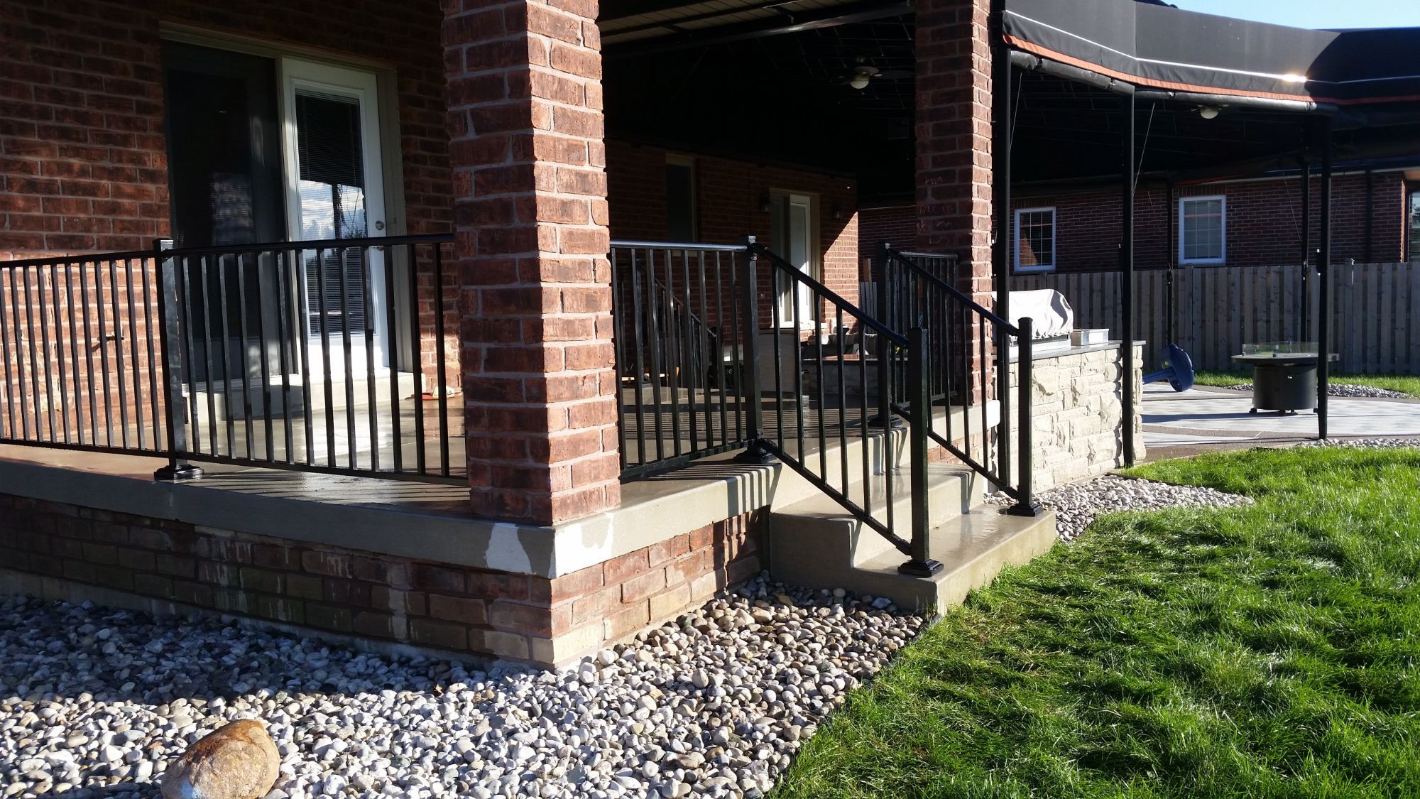 Aluminum handrail on a porch in Belle River, Elite 1 5/8 inch residential top cover in gloss black. Several years later this couple decided that they wanted to do the back of their property with aluminum fence.