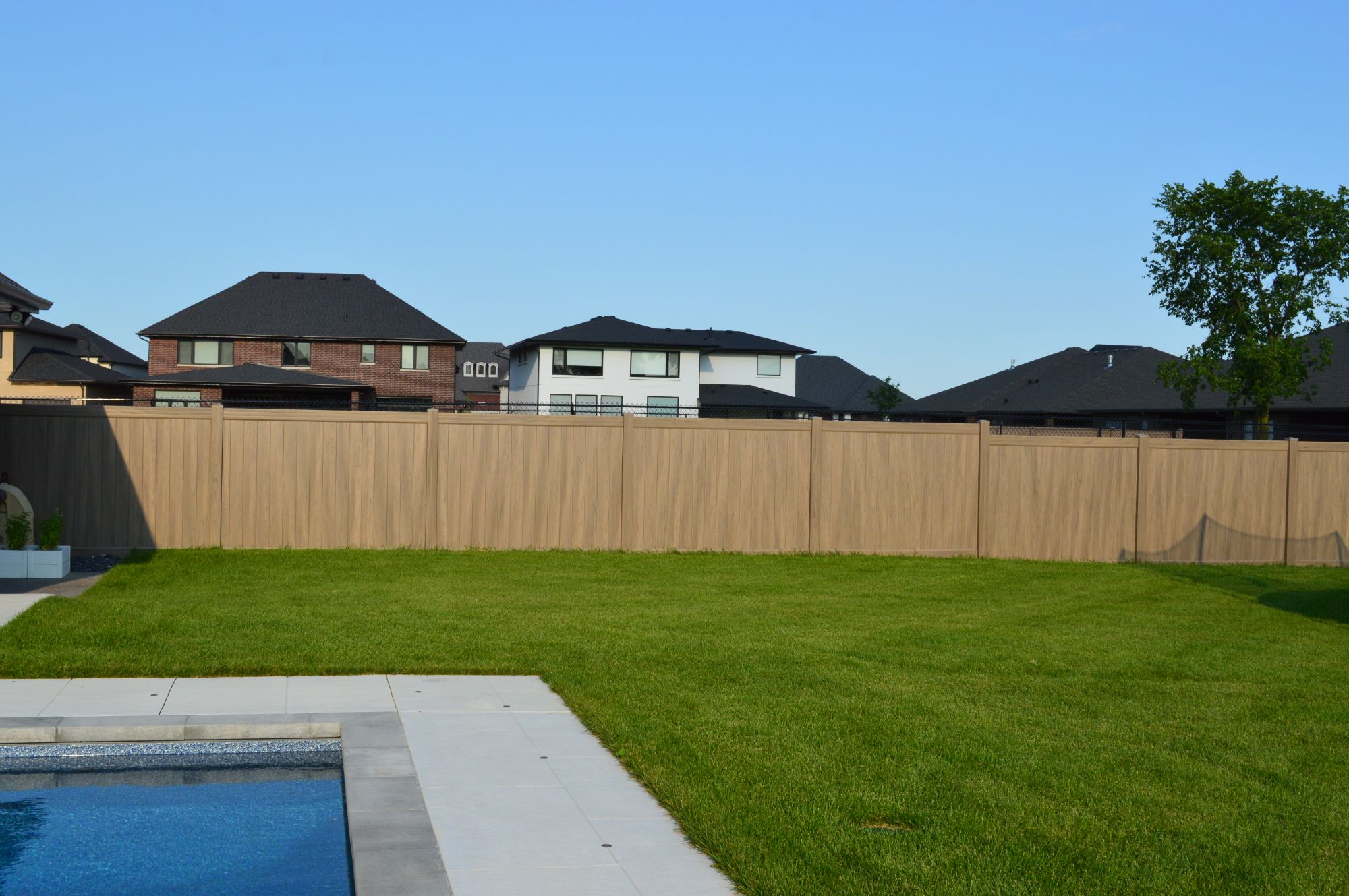 Plastic fencing has become the most common solution to achieving a privacy fence within LaSalle. Suitable for enclosing a pool. In this installation, the Homeland Green Teak fence perfectly matches the yard in this deep lot.
