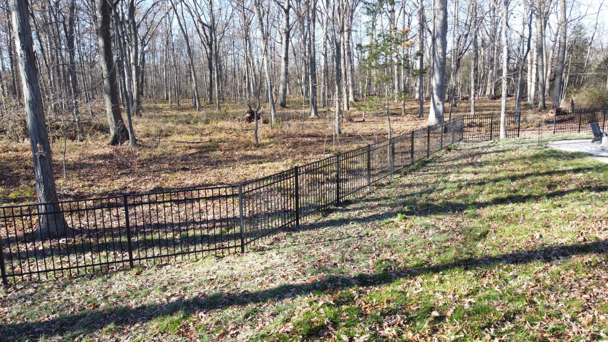 With lakeshore landscaping we extended helped build out this cabin in the woods into a place where the family could relax to and bring the dogs. Set on 40 acres and formerly fully treed, we managed to blend the rod iron fence into the tree line.